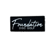Black patch with 'Foundation Disc Golf' text on a textured surface