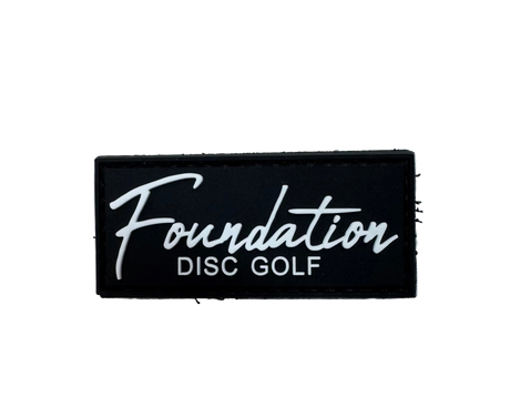Black patch with 'Foundation Disc Golf' text on a textured surface